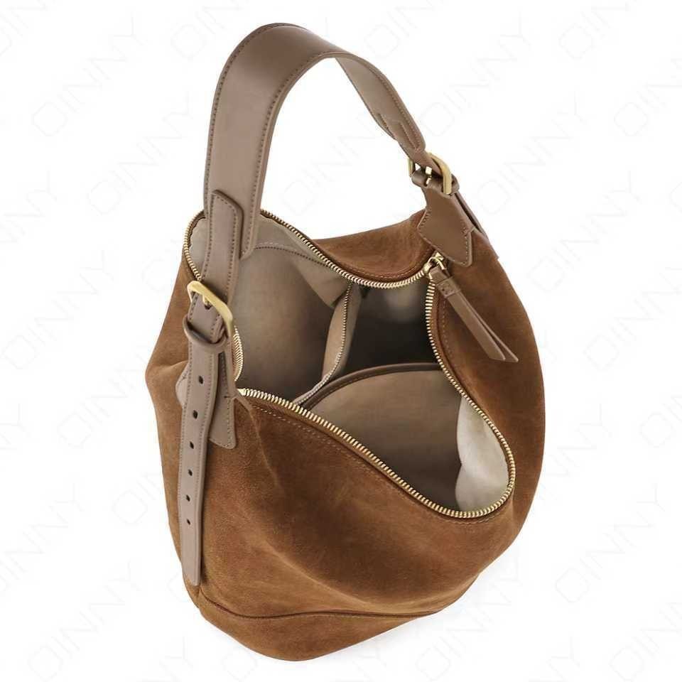 Brown suede handbag with gold zipper on a white background