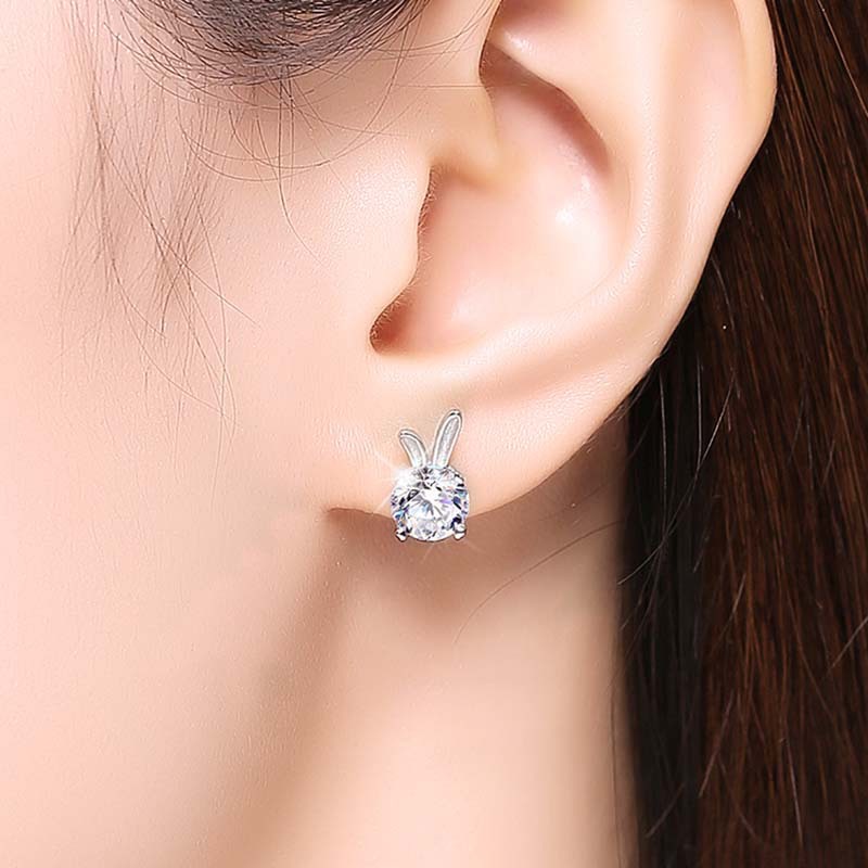 Silver earring worn on a model's ear with a neutral background
